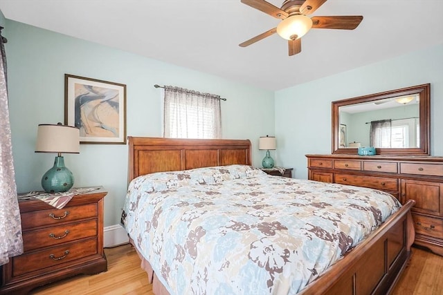 bedroom featuring multiple windows, light wood-style floors, and a ceiling fan
