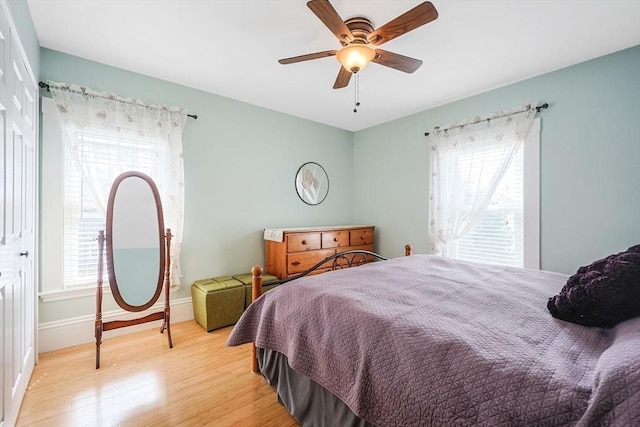 bedroom featuring light wood-style flooring, baseboards, and ceiling fan