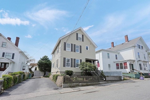 view of front of property featuring a fenced front yard and asphalt driveway