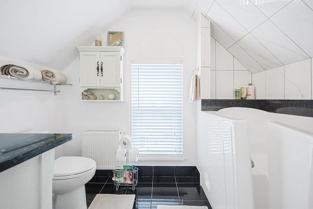 bathroom featuring radiator heating unit, lofted ceiling, and toilet