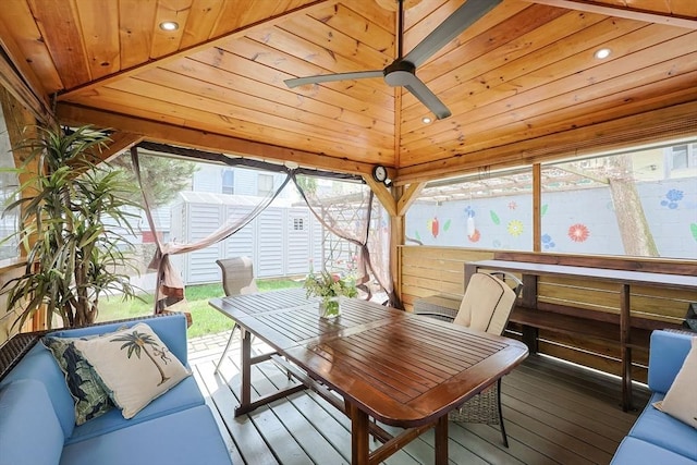 sunroom / solarium featuring a ceiling fan, outdoor dining space, and plenty of natural light