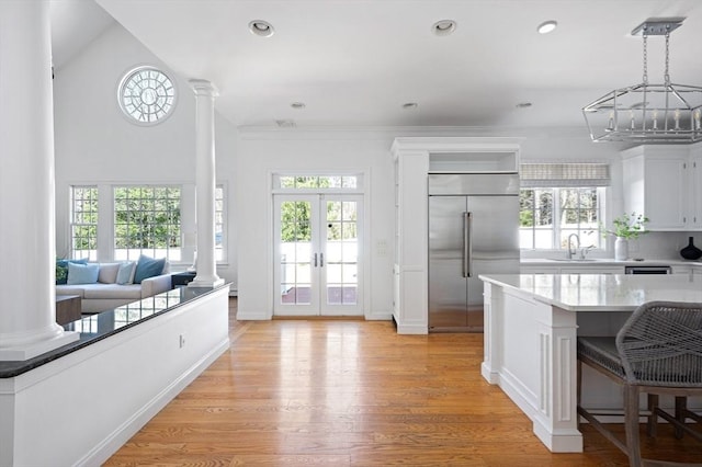 kitchen featuring white cabinets, a sink, built in fridge, and plenty of natural light
