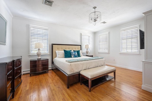 bedroom with a baseboard heating unit, light wood-style flooring, visible vents, an inviting chandelier, and multiple windows