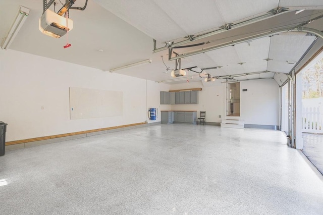 garage with a garage door opener and baseboards