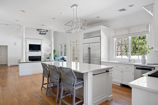 kitchen with a center island, a sink, light countertops, appliances with stainless steel finishes, and visible vents