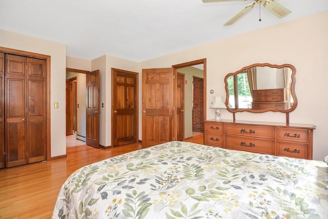 bedroom featuring a baseboard heating unit, light wood-type flooring, ceiling fan, and a closet