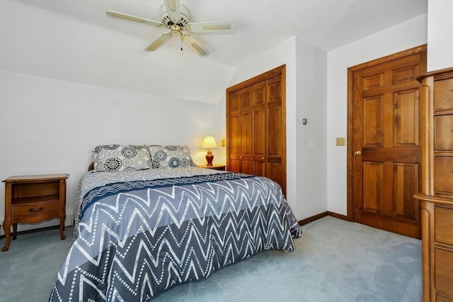 carpeted bedroom with vaulted ceiling, a closet, and ceiling fan