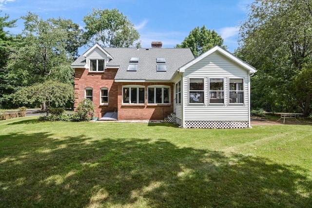 rear view of house featuring a yard