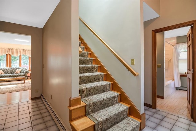 stairway featuring tile patterned flooring and a baseboard heating unit