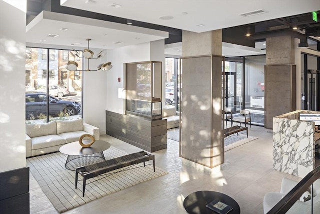 living room featuring a wall of windows, a healthy amount of sunlight, and visible vents