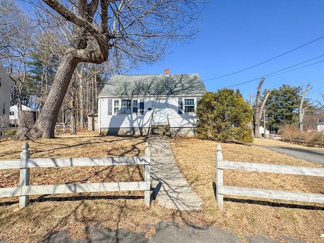 view of front of home featuring a shingled roof, a chimney, and fence