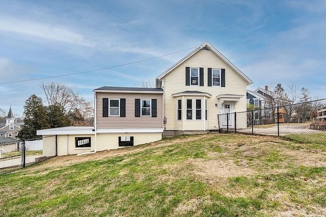 rear view of property with fence and a lawn