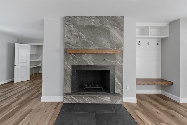 details with hardwood / wood-style floors and a tile fireplace