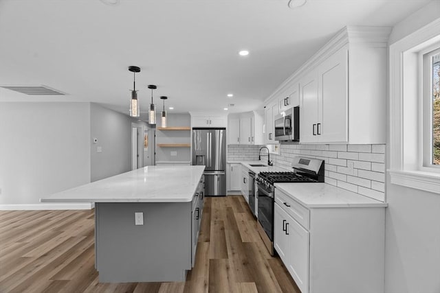 kitchen with a center island, sink, white cabinetry, and stainless steel appliances