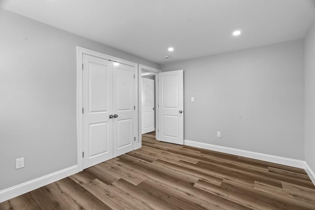 unfurnished bedroom with a closet and hardwood / wood-style floors