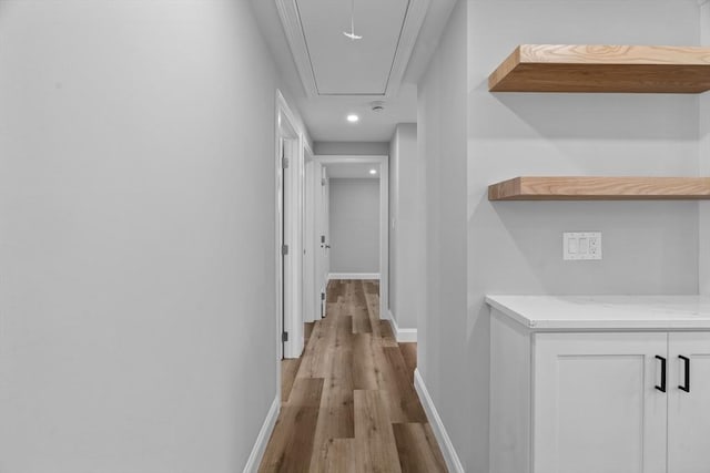 hall with light hardwood / wood-style flooring and ornamental molding