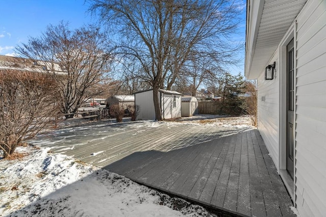 snow covered deck with a storage shed