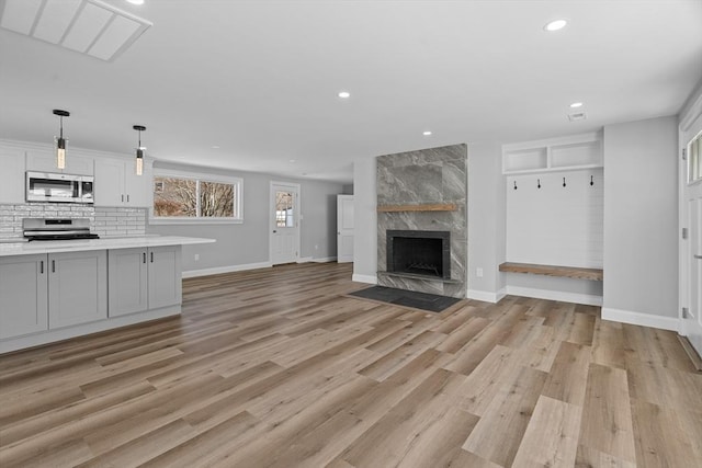 unfurnished living room featuring a fireplace and light hardwood / wood-style floors