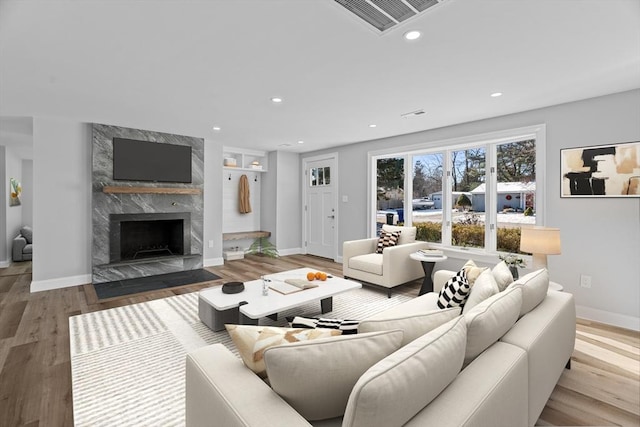 living room with a premium fireplace and light hardwood / wood-style flooring