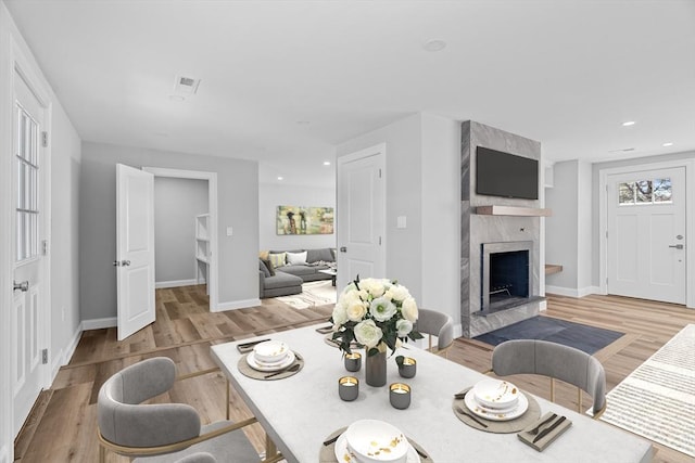 dining space with a fireplace and light hardwood / wood-style floors