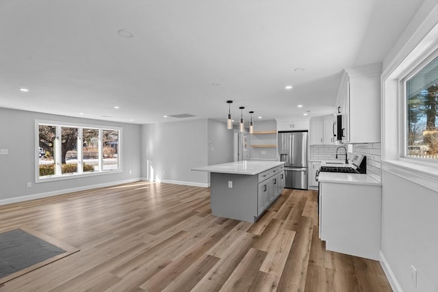 kitchen with a kitchen island, stainless steel fridge with ice dispenser, backsplash, pendant lighting, and white cabinets