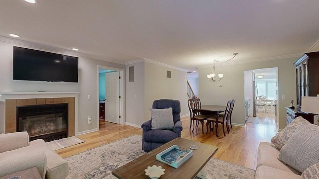 3 Oakwood Ln Unit 3, Worcester, MA 01604 - living area with light wood finished floors, crown molding, a chandelier, a tiled fireplace, and recessed lighting