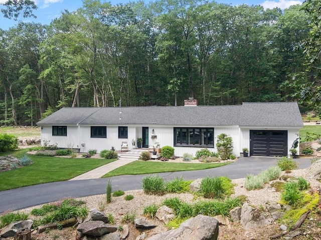 47 Jenkins Rd, Andover, MA 01810 - view of front of property with an attached garage, asphalt driveway, a front yard, a chimney, and a shingled roof