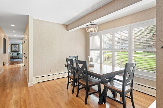 dining room featuring a baseboard radiator, wallpapered walls, wood finished floors, and a chandelier