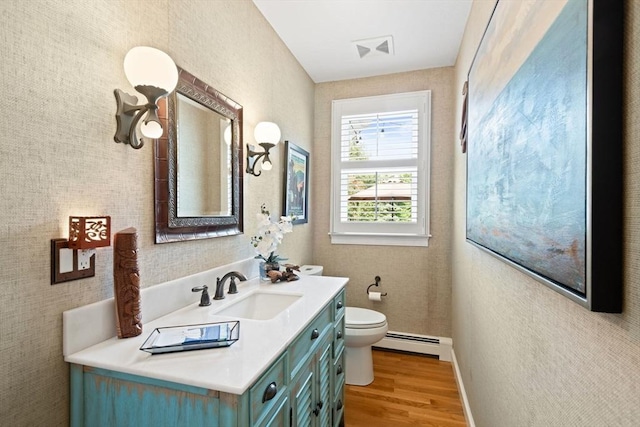 bathroom featuring visible vents, wood finished floors, vanity, a baseboard radiator, and toilet