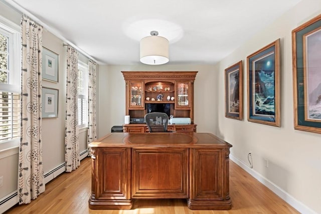 office with baseboards, baseboard heating, and light wood-style flooring