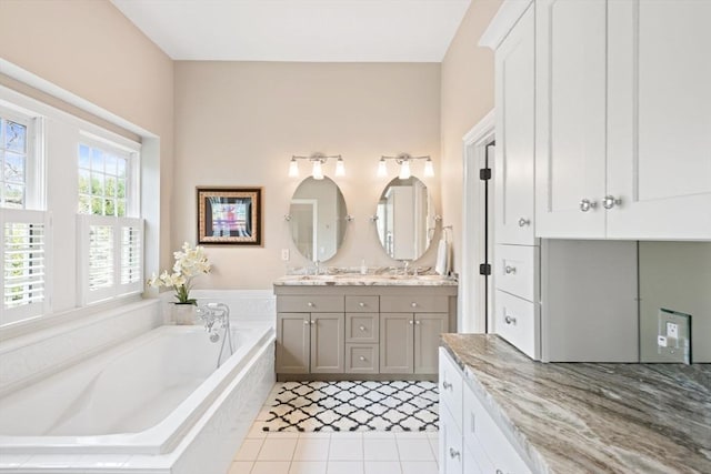 full bath with double vanity, tile patterned flooring, a bath, and a sink