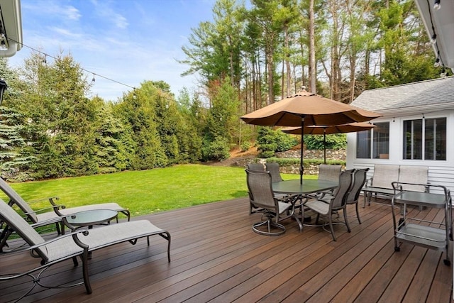 deck with outdoor dining area and a lawn