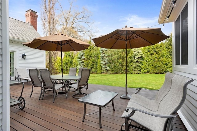 deck featuring a lawn and outdoor dining area