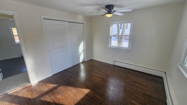 unfurnished bedroom featuring a closet, dark wood finished floors, baseboards, and ceiling fan