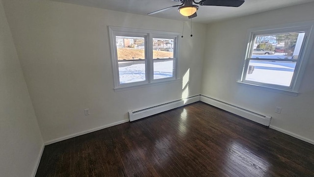 spare room featuring a healthy amount of sunlight, ceiling fan, baseboards, and wood finished floors