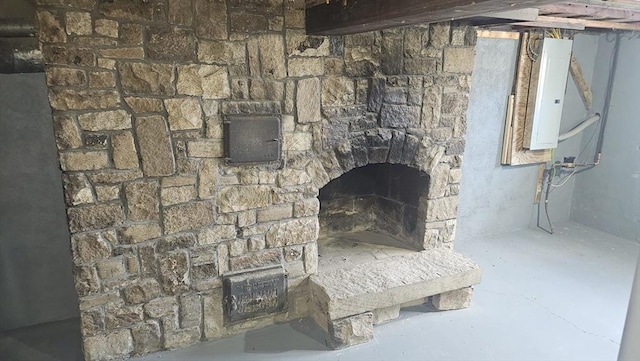 room details featuring electric panel and a fireplace with raised hearth