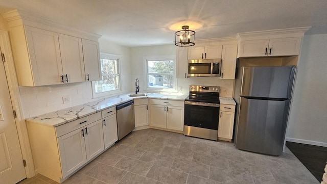 kitchen with a sink, appliances with stainless steel finishes, backsplash, and white cabinets