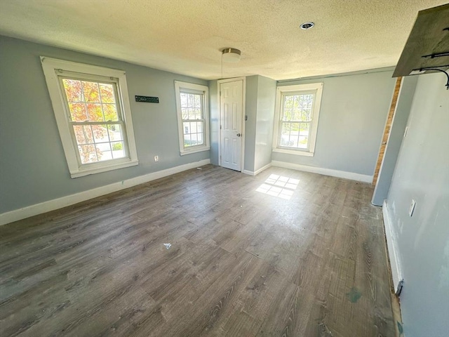 unfurnished bedroom with baseboards, a textured ceiling, and wood finished floors