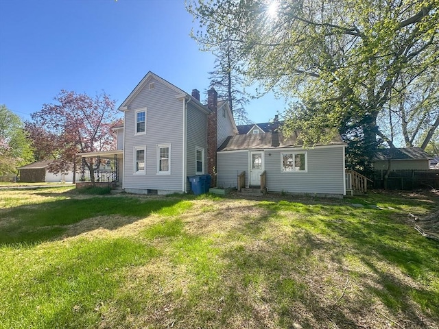 back of property with a lawn, a chimney, and entry steps