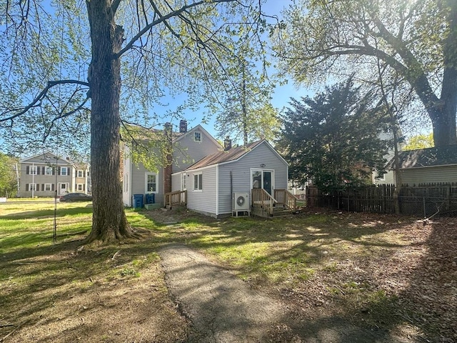 view of home's exterior featuring fence, ac unit, and a yard