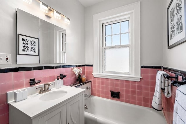 bathroom featuring vanity, a bath, and tile walls