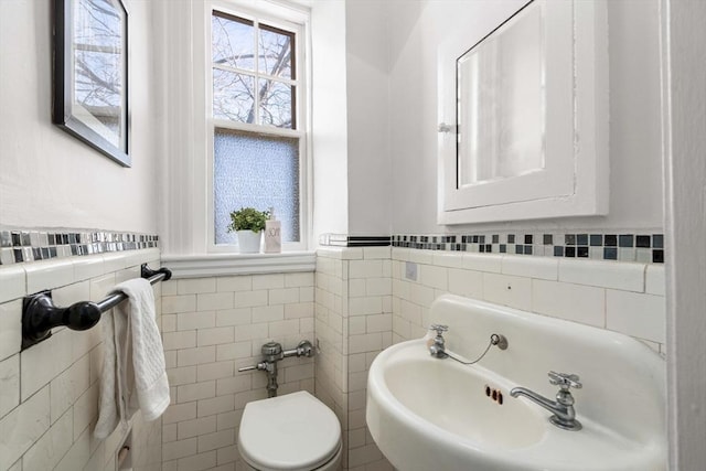 bathroom with tile walls and toilet