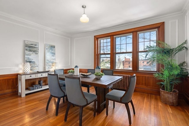 dining area featuring crown molding, radiator, and light hardwood / wood-style floors