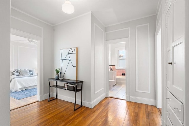 hall with ornamental molding and hardwood / wood-style floors