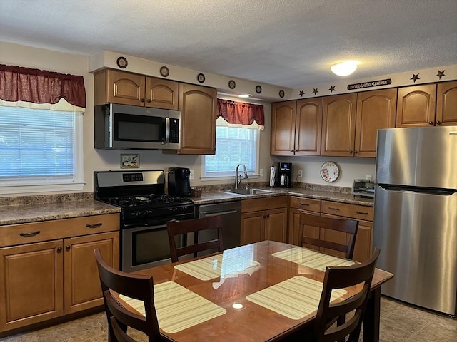 48 Birchcroft, Leominster, MA 01453 - kitchen featuring appliances with stainless steel finishes, dark countertops, a textured ceiling, and brown cabinetry