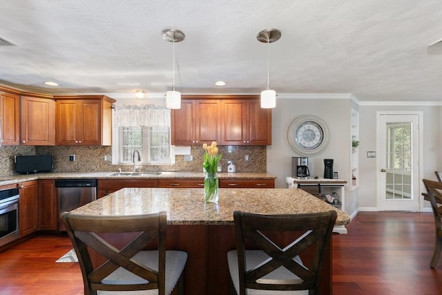 kitchen featuring brown cabinets, stainless steel appliances, a sink, and dark wood-style flooring
