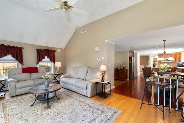 living area featuring ceiling fan, baseboards, wood finished floors, lofted ceiling, and visible vents