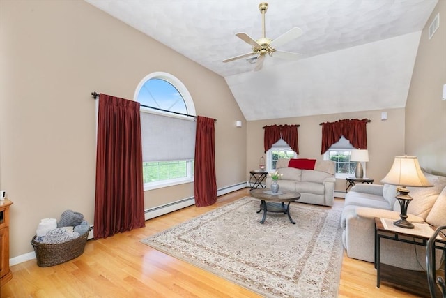 living room with visible vents, a baseboard heating unit, a wealth of natural light, and wood finished floors
