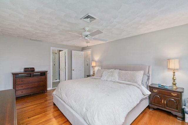 bedroom with visible vents, a ceiling fan, and hardwood / wood-style floors