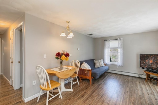 dining space with an inviting chandelier, baseboards, wood finished floors, a baseboard radiator, and visible vents